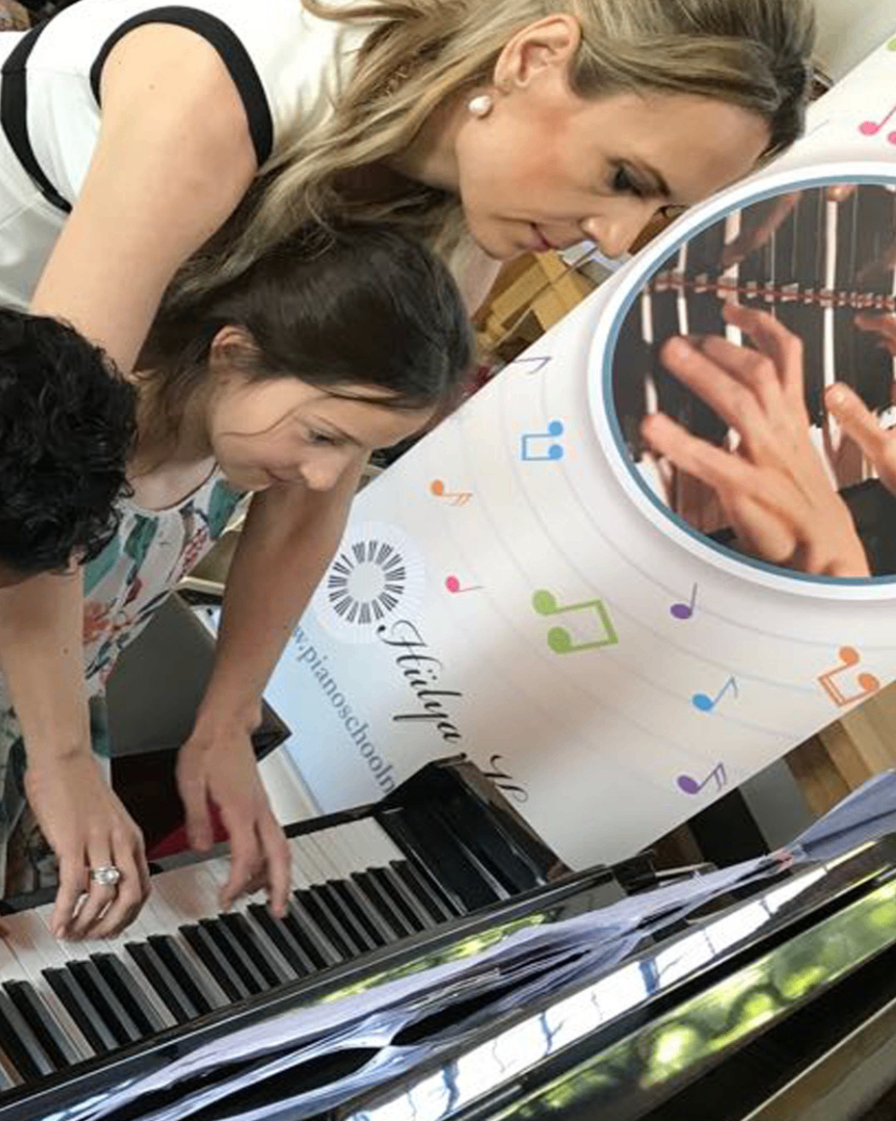 Hülya guiding children at the piano