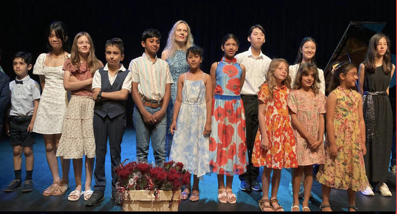 Students and Hülya on stage after a concert