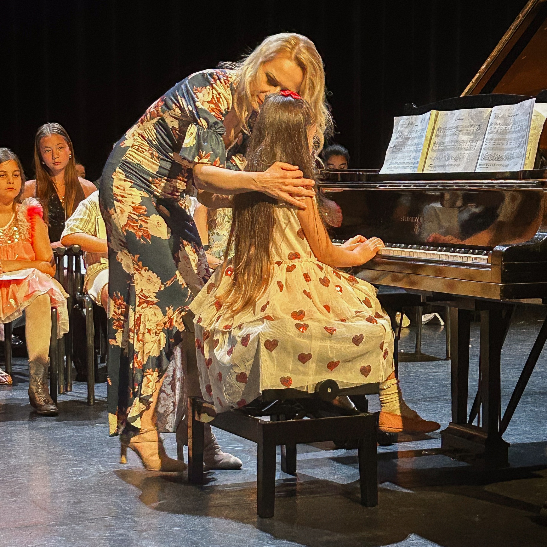 Hülya Keser guiding a young pianist at the grand piano
